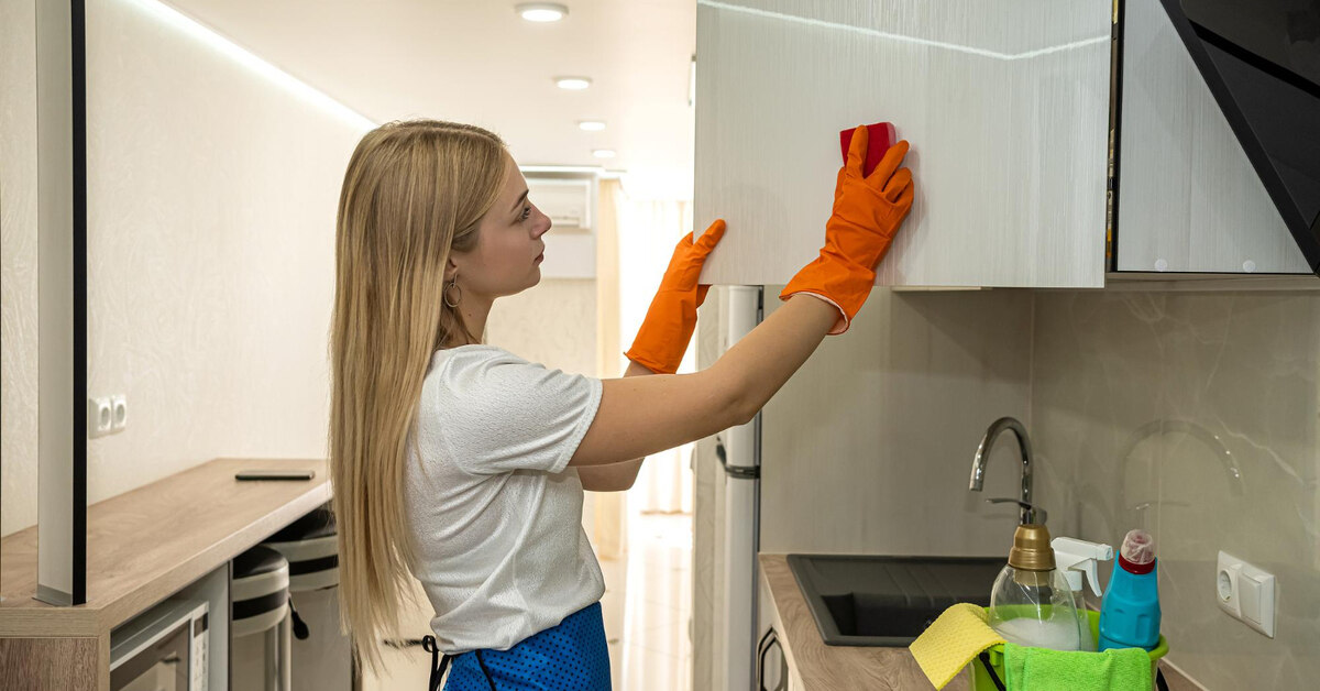 Woman cleans the cabinets